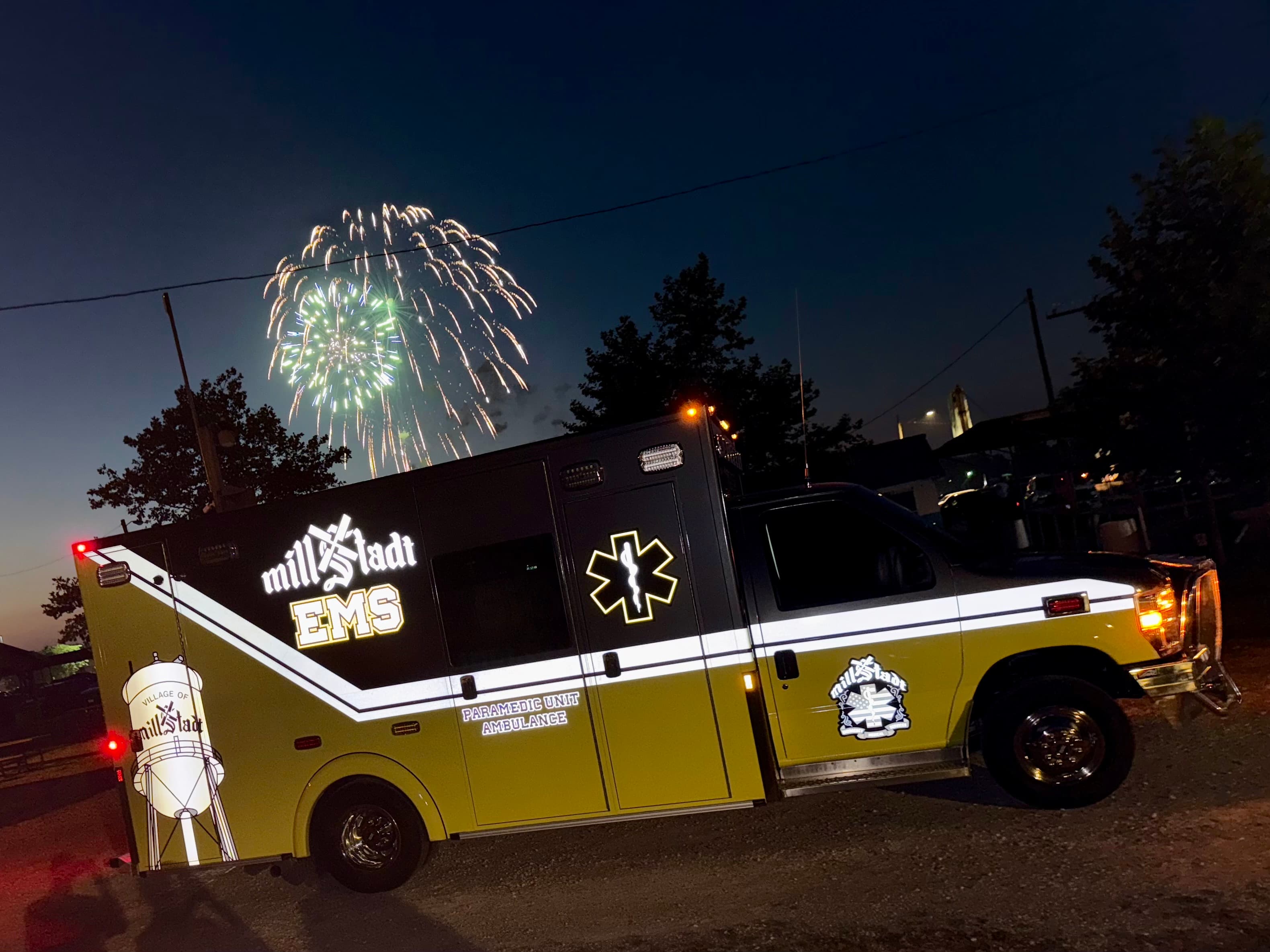 Millstadt EMS ambulance at night with fireworks overhead